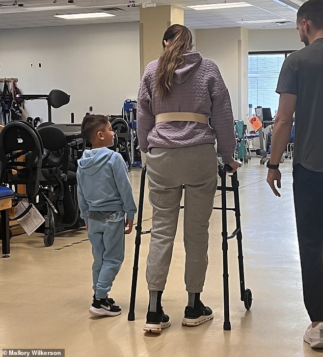 Pictured: Wilkerson made enough progress to graduate to a walker, with her little boy proudly at her side
