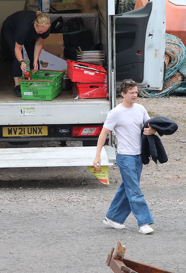 Arriving to the dock first, Tom looked in cheerful spirits as he waved at fans on the shore, before making a solo journey to the set