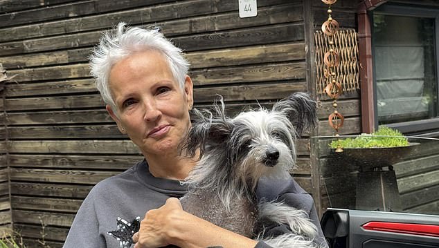 Mrs Girdiefski, pictured with Ziggy, outside the lodge she and her husband own at Fritton Lake