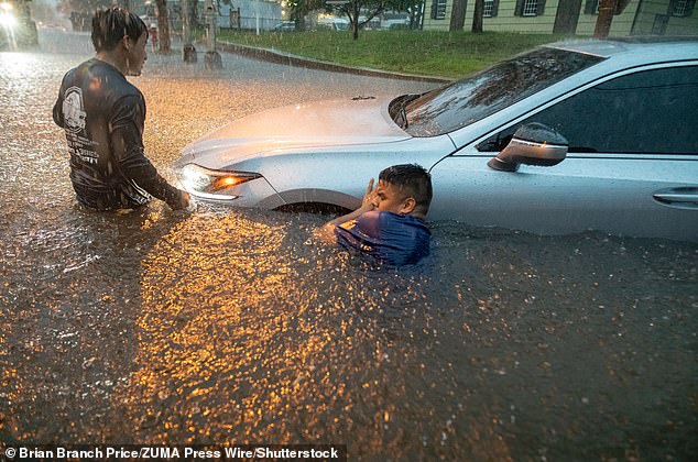 Men try to tow their car out of the rain swell during a flash flood on Watchung Avenue in Plainfield, New Jersey