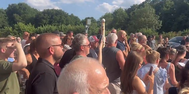 Hundreds of people massed outside the migrant hotel to join the protest there on Sunday