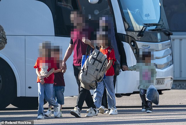 A family prepares to get on to a coach to start a new life in the UK