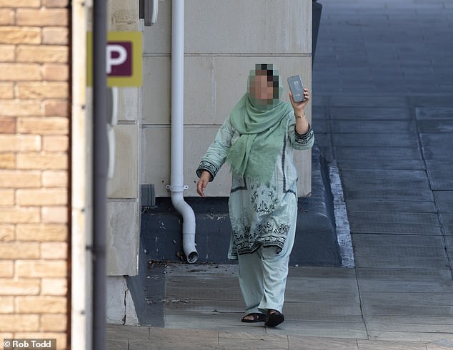 A woman on her smartphone returning to her hotel accommodation