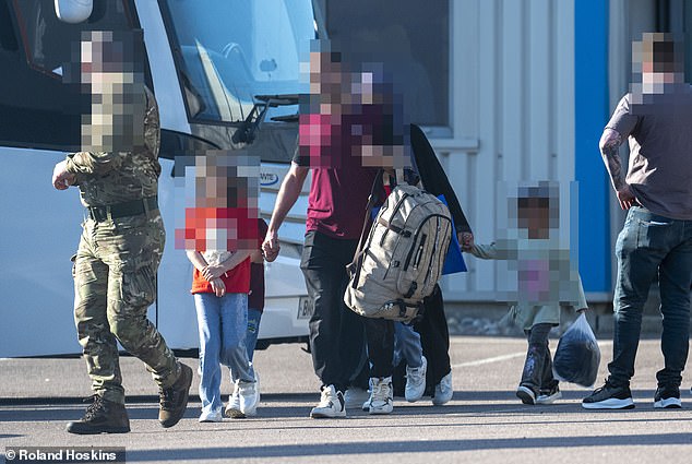 A soldier leads a family to a second coach close to where their plane landed in late May