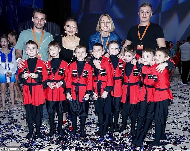 The boy, circled, is said to be following in his mother's - second from left in back row - footsteps by performing on stage as a gymnast