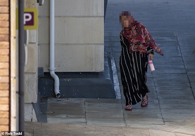 A woman in traditional Afghan dress walks into the hotel in Bracknell