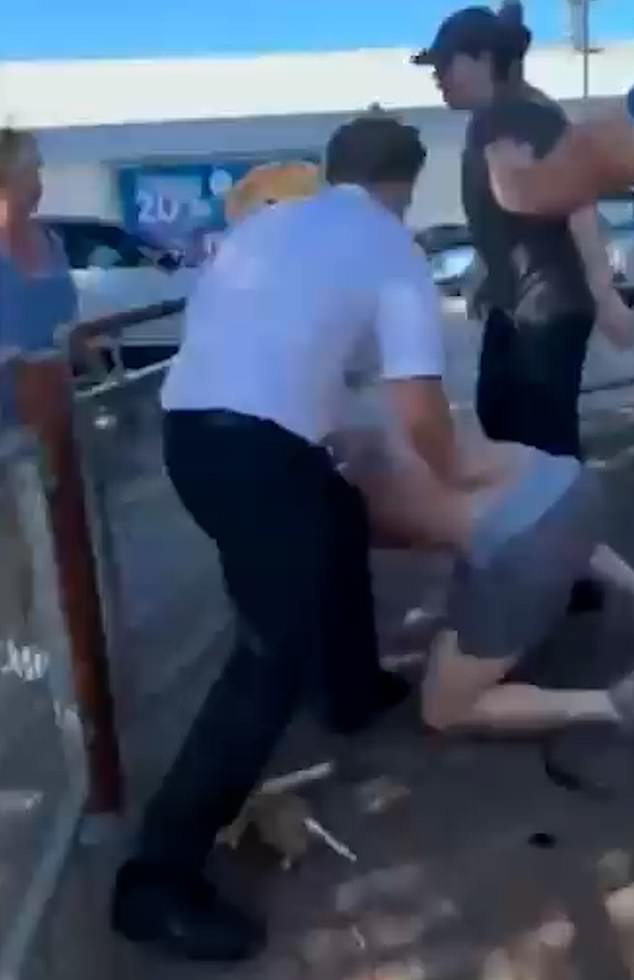 The shirtless customer is finally thrown off the staff member after several other people intervene