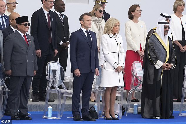 French President Emmanuel Macron and his wife Brigitte Macron stand with Indonesia's President Prabowo Subianto during the Bastille Day parade on Monday