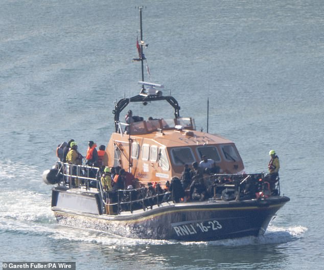 A group of migrants are ferried to Dover, Kent, on an RNLI vessel after being picked up from a small boat in the Channel