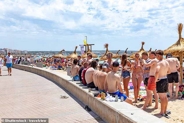 According to officials, being 'bare-chested' in public spaces - particularly on seafront promenades or on adjacent streets - can also result in fines (pictured: tourists in Palma de Mallorca)