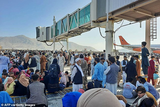 People in Kabul waited on an airport tarmac to be evacuated from Afghanistan after the Taliban took over