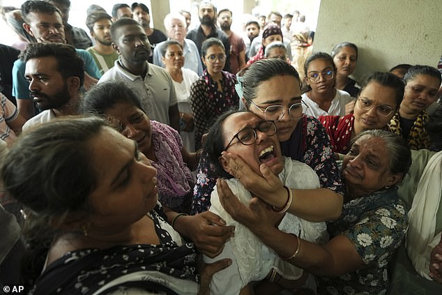 ayushi Lawrence, center, wife of Lawrence Christian, a victim of the June 12 Air India plane crash, grieves during his funeral, in Ahmedabad, India, Sunday, June 22, 2025