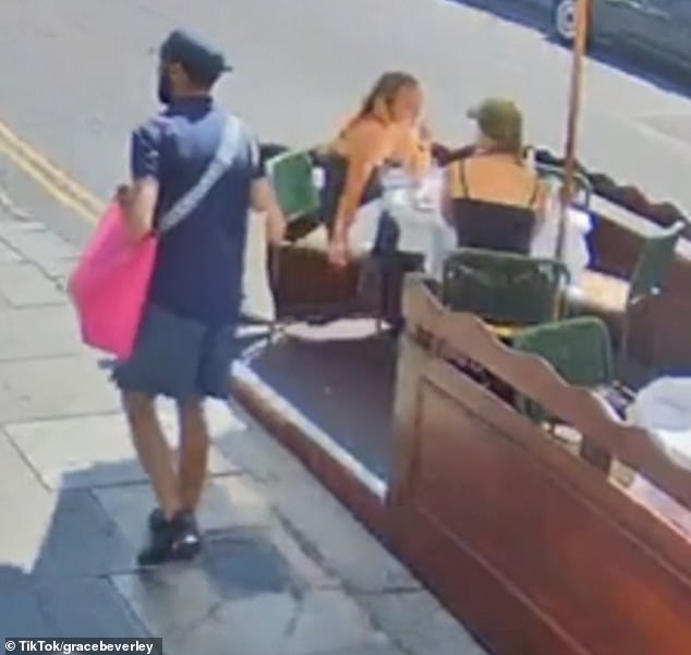The thief (pictured left) initially walked past the duo before clocking the bag and returning to steal it