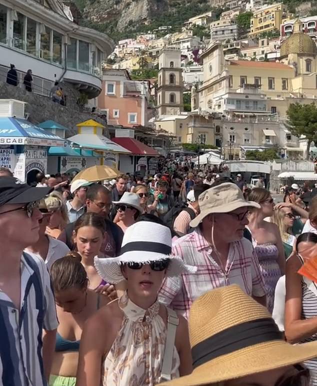 Sunseekers in Greece and Italy have taken to social media to express how their expectations for the destinations were very different from the reality. Pictured: A crowd in Positano, Italy