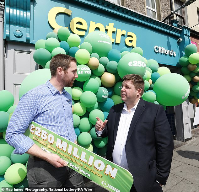 The family, who have chosen to remain anonymous, bagged the largest EuroMillions prize in Irish history (Pictured: Cian Murphy, right, CEO of National Lottery, alongside store manager Simon Champ from Clifford's Centra on Shandon Street in Cork City centre)