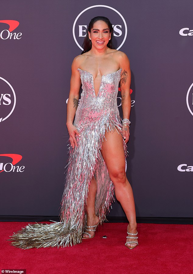 Robin Azron - head instructor at Peloton - wore a strapless, metallic silver gown that contained a very low-cut neckline and an over-the-top skirt made out of tassels