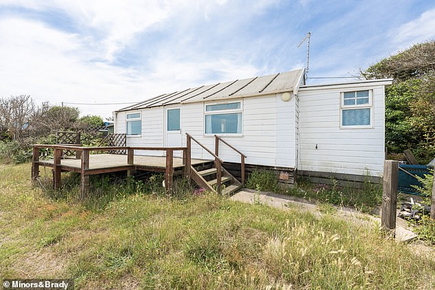 The timber-framed white chalet sits on a wrap-around plot and has a 'decked terrace, where you can savour the spectacular sea views – a space equally suited to summer BBQs, al fresco dining or simply relaxing in the afternoon sunshine’.