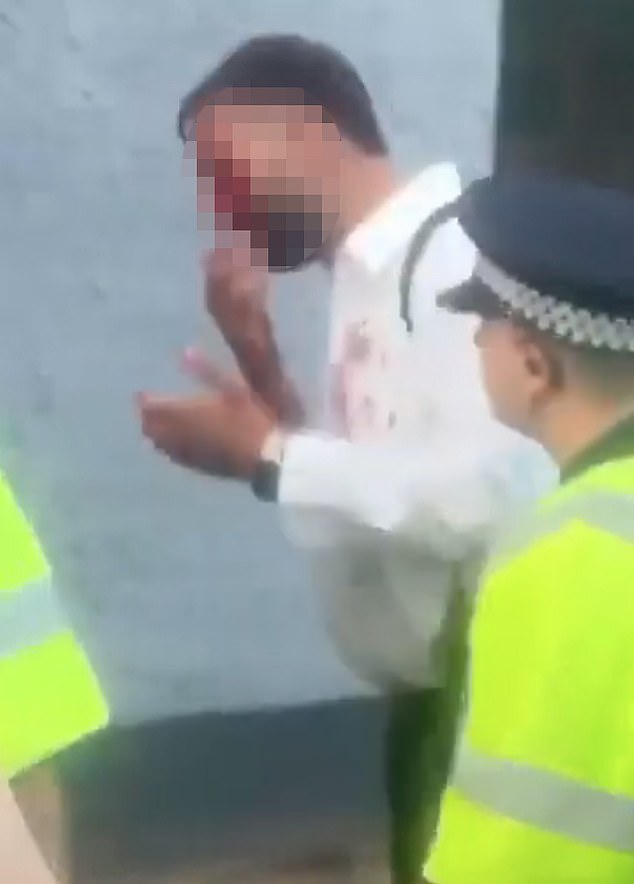 A man thought to be one of the security guards attacked close to the Bell Hotel is helped inside by police