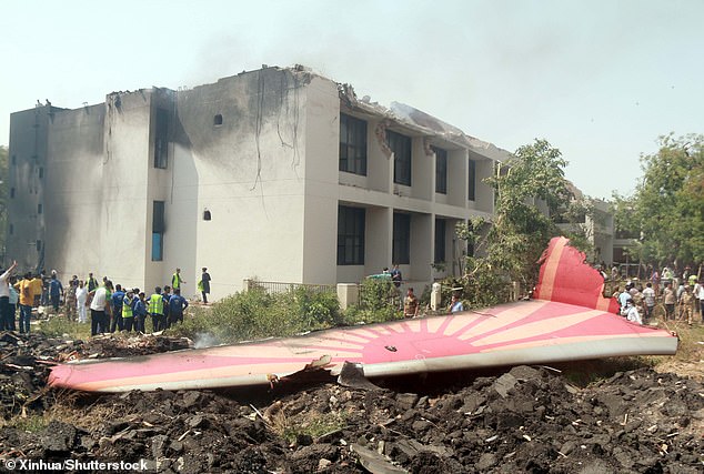 People look at the debris of an Air India plane crashed in Ahmedabad of India's Gujarat state. Before the flight, both pilots had an adequate rest period and were found 'fit to operate' following a breath analyser test, the report said
