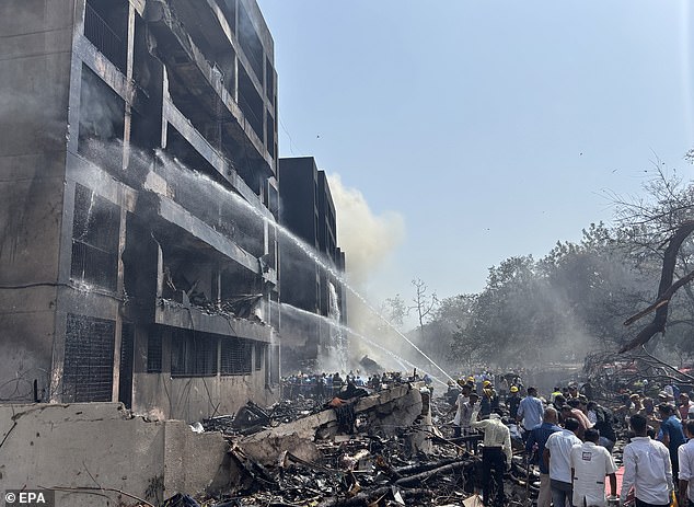 Firefighters work at the site of the crash near Sardar Vallabhbhai Patel International Airport