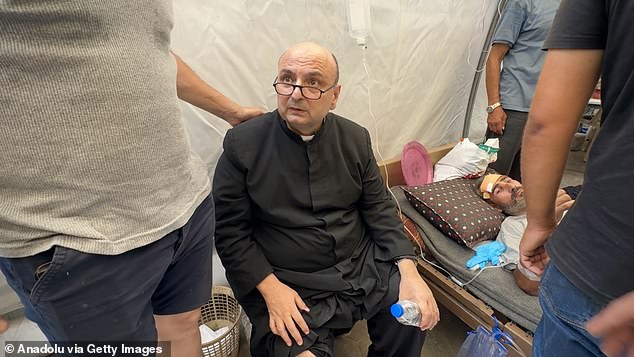 Wounded Palestinians, including Father Jebrail Romanelli, are brought to Al-Ahli Baptist Hospital after an Israeli attack targeted the Holy Family Church in eastern Gaza City