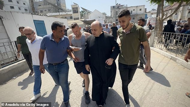 Wounded Palestinians, including Father Jebrail Romanelli, are brought to Al-Ahli Baptist Hospital