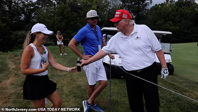 Pictured: Trump hands a Diet Coke to a NJ resident as guests and volunteers followed golfers on the course at the LIV Pro Am Tournament at Trump National in Bedminster, July 2022