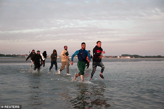 The publication of the Home Office civil servants' pay came as migrants were seen sprinting across a beach at Gravelines, northern France, this morning to board a dinghy bound for Britain