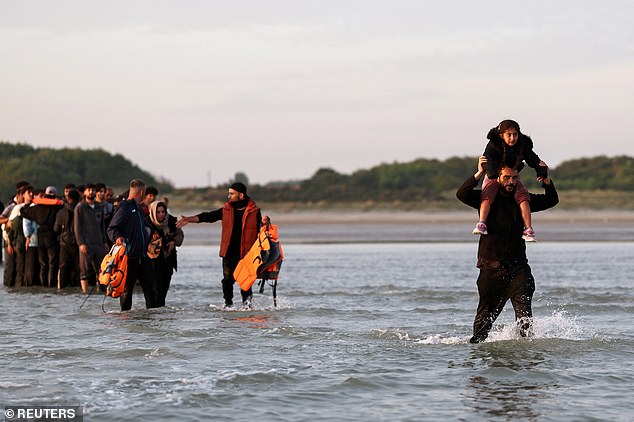 The group of migrants included a men who held a child aloft on his shoulders