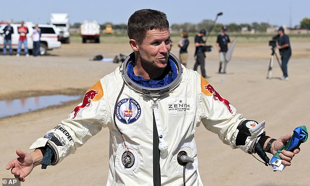 Felix Baumgartner of Austria gestures prior to speaking with the media after successfully jumping from a space capsule lifted by a helium balloon in Roswell, N.M., October 14, 2012