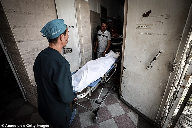 Bodies of the Palestinians are taken to Al-Ahli Baptist Hospital morgue for funeral arrangements following the Israeli strike hit the Catholic Holy Family Church