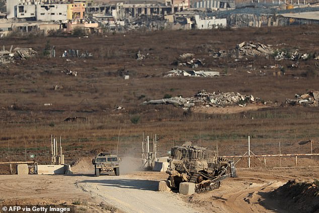 Israeli troops and an army bulldozer near the separation fence between Israel and Gaza on July 17