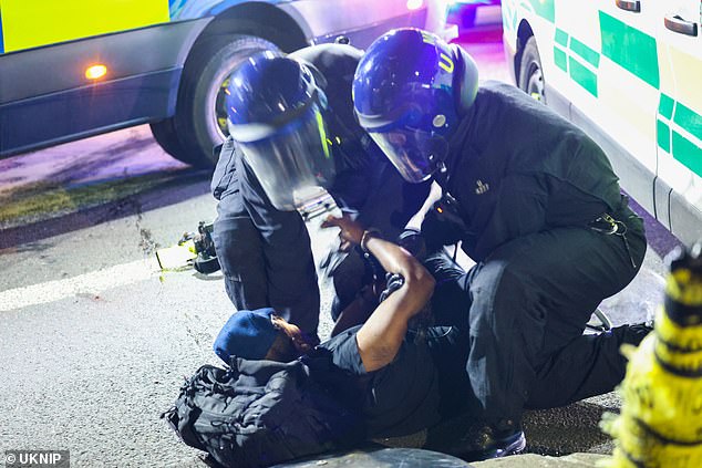 A protestor appears to be detained by police