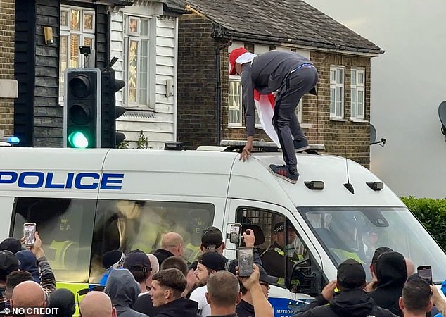Earlier the man could be seen scrambling up the windscreen of the van, with officers trapped inside