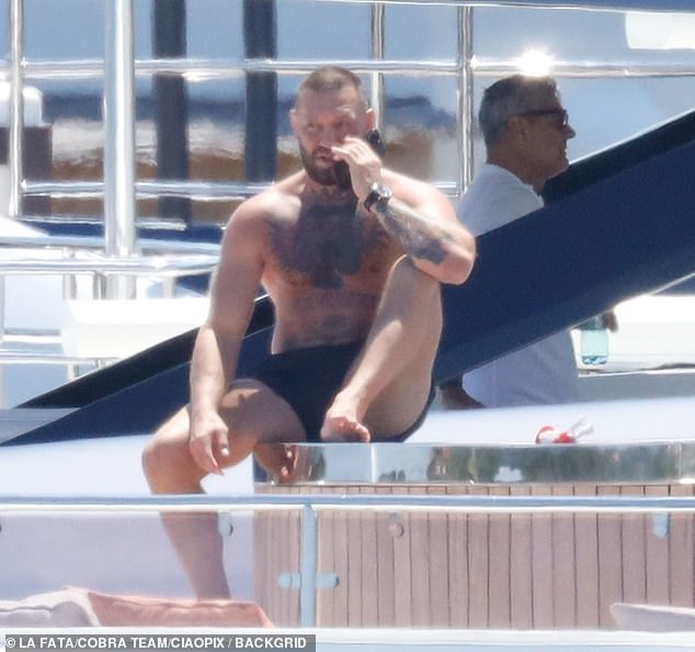 The former UFC fighter showed off his muscular and tattooed frame as he went shirtless in a pair of black board shorts