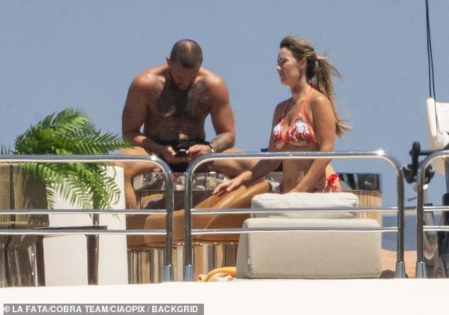 His partner Dee showed off her incredible figure in a vibrant coral patterned two-piece as she put on a united display with Conor