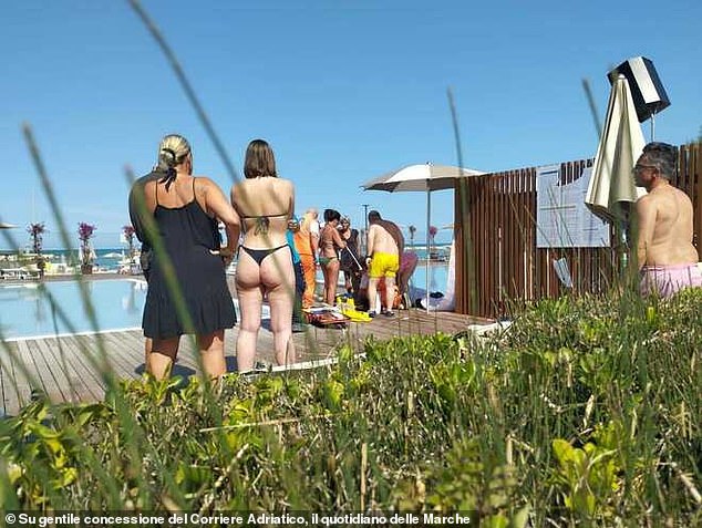 Some appeared to be on their knees administering first aid as staff members hurried a spinal board to the scene, fearing the skydiver may have suffered severe injuries