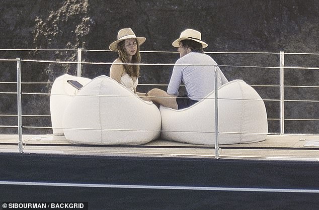 De Armas was seen placing a tender hand on Cruise's leg as they chatted, with the two Oscar nominees wearing matching fedora straw hats