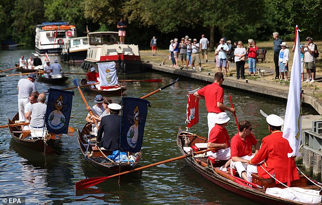 Swan uppers travel up the River Thames while searching for swans during the annual swan upping