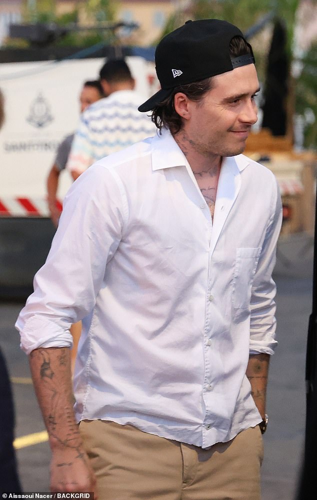 Meanwhile Brooklyn wore a white shirt and tan trousers with a baseball, that was worn backwards, and sandals