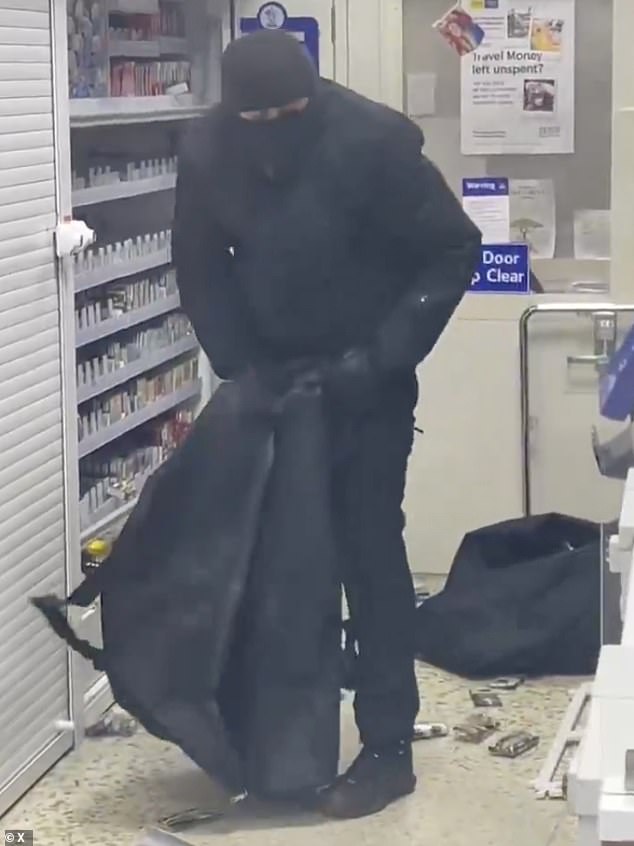 A masked thief - dressed all in black - loading stolen vapes in to a large bag in a Tesco store this year