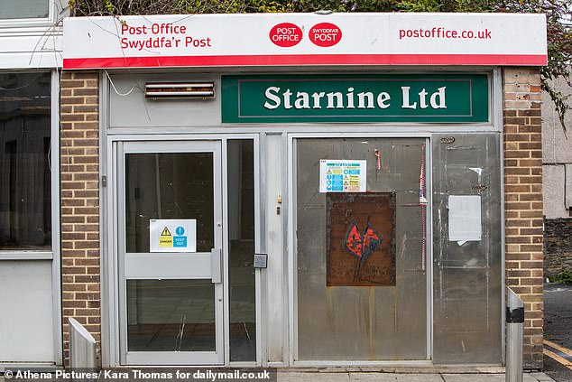 A closed post office in Llanelli, boarded up with the cash machine blocked off