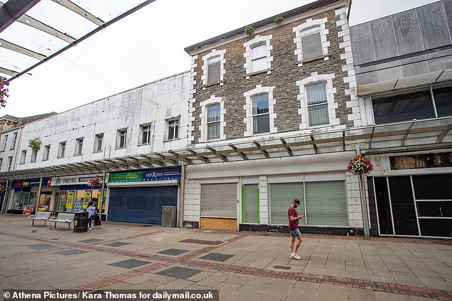 A row of boarded up and blocked-off shops in the empty town centre