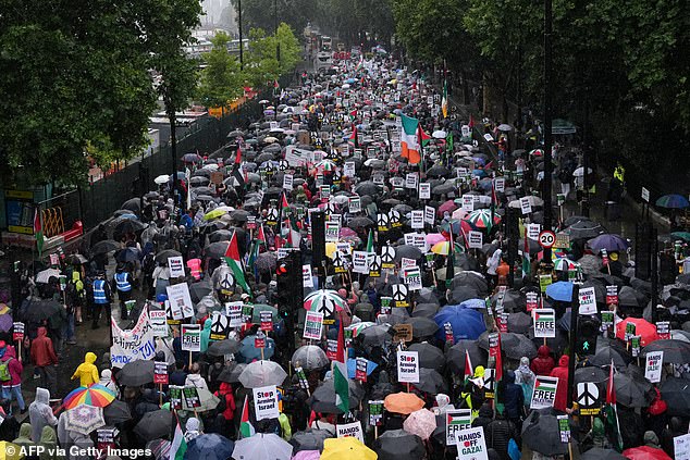 Pro-Palestinian supporters marched with placards and umbrellas in the rain in central London on Saturday