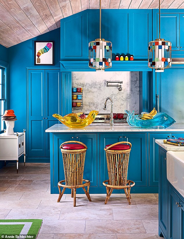 Vintage rattan stools create a bar area in the kitchen and dining room, below pendant lights designed by Jonathan. The cypress-wood ceiling is original to the space.