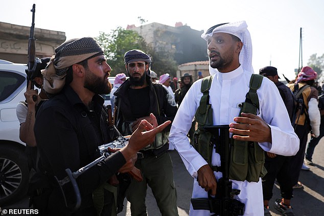 Bedouin fighters talk at an Internal Security Forces checkpoint working to prevent Bedouin fighters from advancing towards Suwayda, Syria, July 19