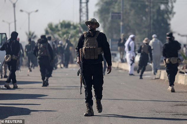 An Internal Security Forces officer walks at an Internal Security Forces checkpoint working to prevent Bedouin fighters from advancing towards Suwayda