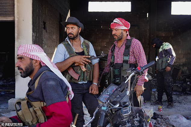 Bedouin fighters stand with their weapons after sectarian clashes on July 19