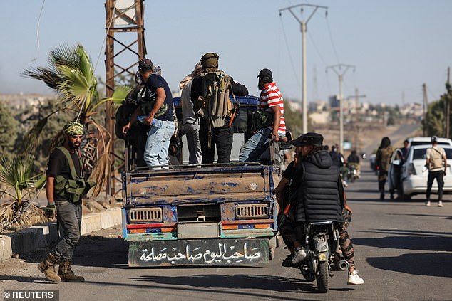 Bedouin fighters stand in the back of a truck at an Internal Security Forces checkpoint