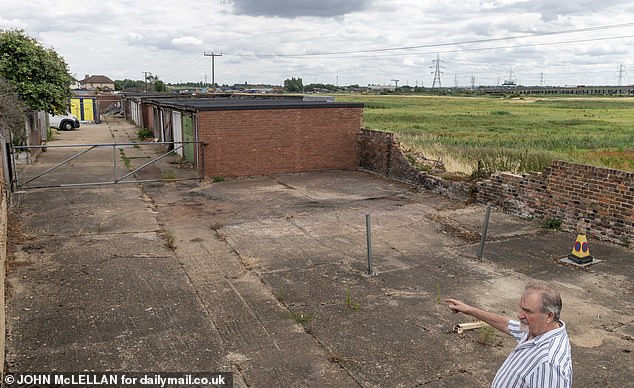 Dan points to the devastation the fire caused to a village wall - which still stands ruined
